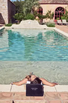a woman laying in the water in a swimming pool at La Signoria & Spa in Calvi