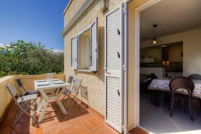 a patio with a table and chairs on a balcony at Appartement moderne avec vue sur montagne à Taglio-Isolaccio in Taglio-Isolaccio