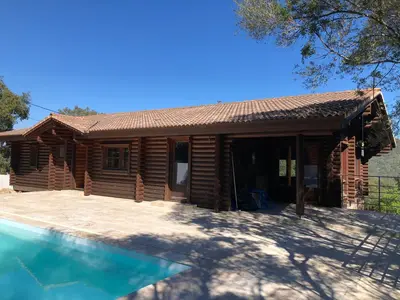 a log cabin with a pool in front of it at Grande maison avec piscine in Porto-Vecchio