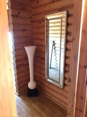 a mirror and a vase in the corner of a room at Grande maison avec piscine in Porto-Vecchio