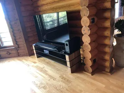 a living room with a flat screen tv in a log cabin at Grande maison avec piscine in Porto-Vecchio
