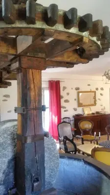 a living room with a large wooden table and a room at Le Moulin de l'Ostriconi in Novella