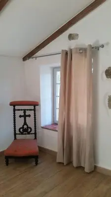 a room with a chair and a window at Le Moulin de l'Ostriconi in Novella