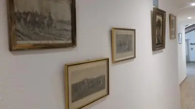 a group of framed pictures on a wall at Le Moulin de l'Ostriconi in Novella