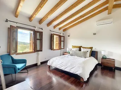 a bedroom with a bed and a blue chair at Domaine de Tappa - Casa Filicina in Sollacaro