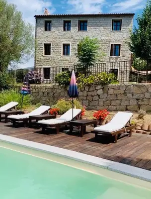 a pool with chaise lounge chairs and a building at Domaine de Tappa - Casa Filicina in Sollacaro