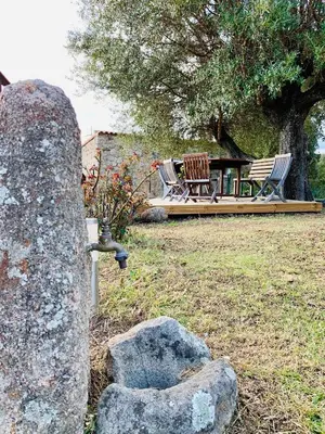 a rock with a water faucet in a yard at Domaine de Tappa - Casa Filicina in Sollacaro