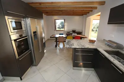 a kitchen with stainless steel appliances and a dining room at Domaine de Tappa - Casa Filicina in Sollacaro