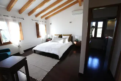 a bedroom with a bed with white sheets and a window at Domaine de Tappa - Casa Filicina in Sollacaro