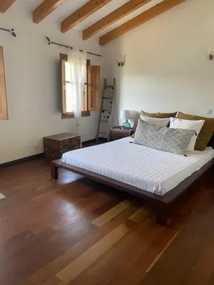 a large bed in a room with wooden floors at Domaine de Tappa - Casa Filicina in Sollacaro