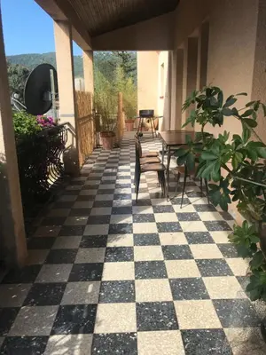 a patio with a checkered floor and tables and chairs at U Ricordu in Prunelli-di-Fiumorbo