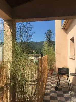 a grill on a patio with a view of the mountains at U Ricordu in Prunelli-di-Fiumorbo