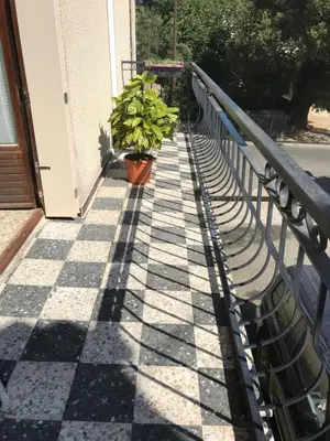 a plant in a pot sitting on a tiled sidewalk at U Ricordu in Prunelli-di-Fiumorbo