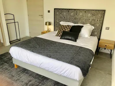 a bedroom with a large bed with black and white pillows at Pavillon de la Trinité in Porto-Vecchio