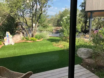 a view of a garden from a patio with an umbrella at Pavillon de la Trinité in Porto-Vecchio
