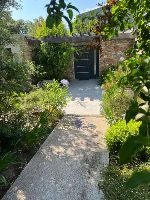 a walkway leading to a door in a garden at Pavillon de la Trinité in Porto-Vecchio