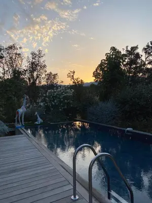 a swimming pool next to a wooden deck at Pavillon de la Trinité in Porto-Vecchio