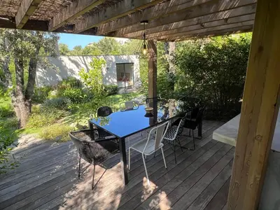 a table and chairs on a wooden deck at Pavillon de la Trinité in Porto-Vecchio