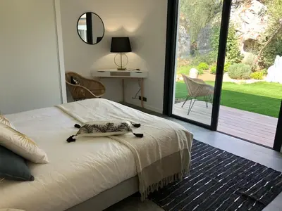 a bedroom with a bed with a cat on it at Pavillon de la Trinité in Porto-Vecchio