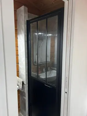 a glass door in a bathroom with a sink at Chalet zen in Peri