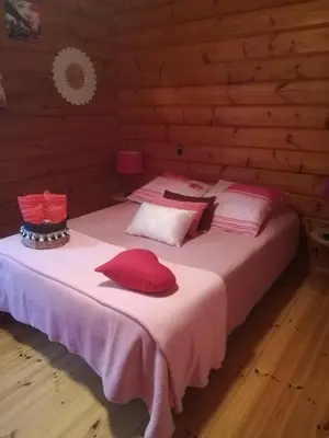 a bed with red pillows on it in a room at Chalet zen in Peri