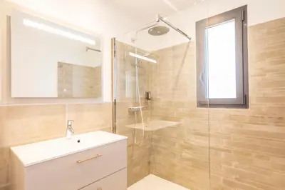 a bathroom with a sink and a glass shower at Villa 19 in Zonza