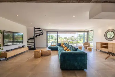 a living room with blue couches and a staircase at Villa 19 in Zonza