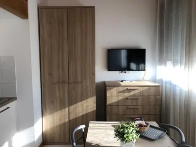 a room with a table and a tv and a cabinet at Résidence Porto Marine in Porto Ota