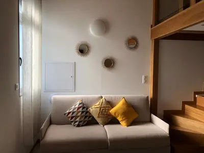 a living room with a couch with pillows on it at Résidence Porto Marine in Porto Ota