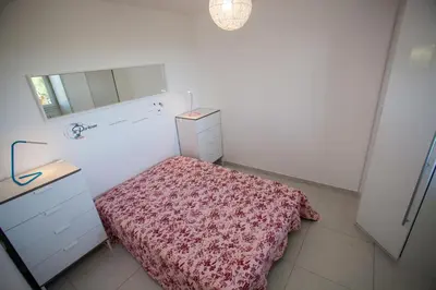 a bedroom with a bed and a dresser and a mirror at Résidence Padro in Calvi