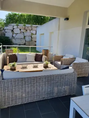 a wicker table and chairs on a patio at VILLA GOLFE AJACCIO près des plages in Ajaccio