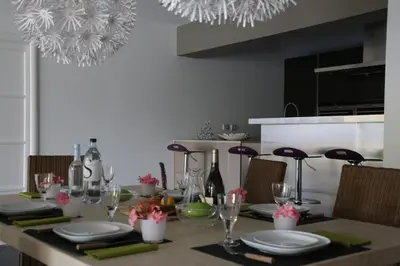 a dining room table with plates and wine glasses at VILLA GOLFE AJACCIO près des plages in Ajaccio