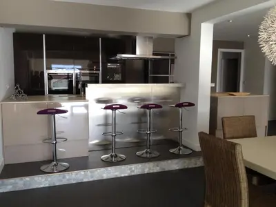 a kitchen with purple bar stools and a table at VILLA GOLFE AJACCIO près des plages in Ajaccio