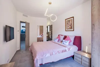 a bedroom with a large bed and a tv at Villa No Stress Aria di Petra in Olmeto