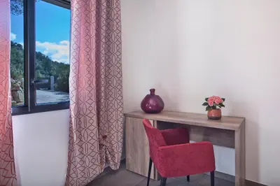 a room with a table and a chair and a window at Villa No Stress Aria di Petra in Olmeto