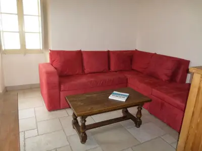 a red couch in a living room with a coffee table at Maison de village in Moltifao