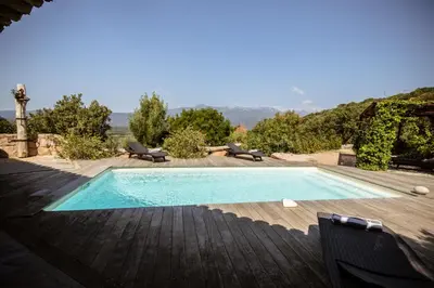 a patio with two chairs and a pergola at Casa Laricciu in Figari
