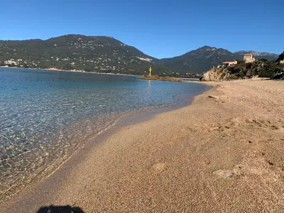 a beach with water and mountains in the background at T3 vue mer in Propriano