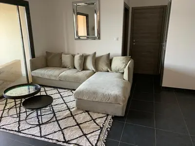 a living room with a couch and a table at T3 vue mer in Propriano