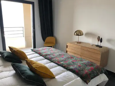 a bedroom with a bed and a dresser and a window at T3 vue mer in Propriano