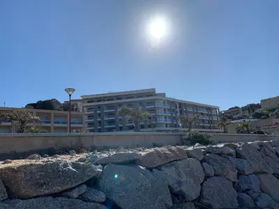 a building behind a pile of rocks in front of a building at T3 vue mer in Propriano