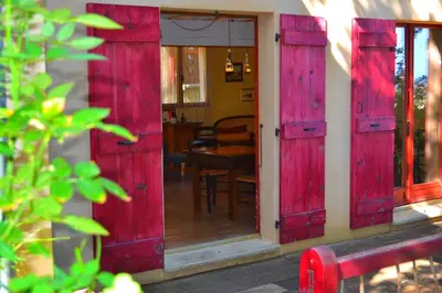 a pair of red shutter doors on a house at Maison de la Vigne in Venzolasca