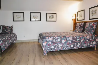 a bedroom with a bed and a couch at Maison de la Vigne in Venzolasca
