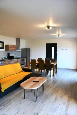a living room with a yellow bed and a table at Cosy vue mer in Olmeto