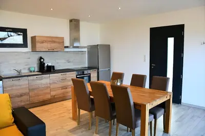 a kitchen with a wooden dining table and chairs at Cosy vue mer in Olmeto