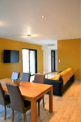 a living room with a table and chairs and a bed at Cosy vue mer in Olmeto