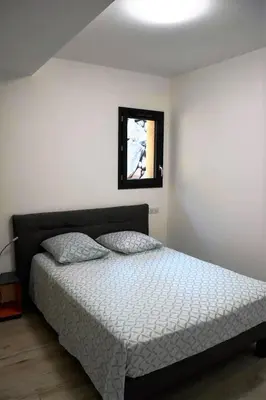 a bedroom with a bed and a window at Cosy vue mer in Olmeto