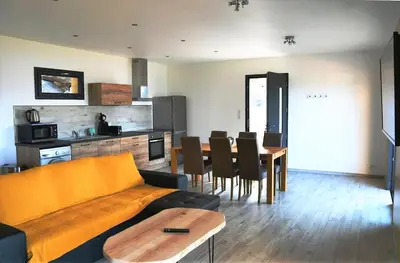 a living room with a couch and a table at Cosy vue mer in Olmeto