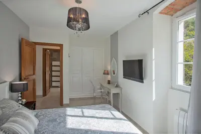 a bedroom with a bed and a desk and a television at LA SOURCE 4 chambres in Valle d'Alesani