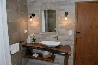 a bathroom with a sink and a mirror at LA SOURCE 4 chambres in Valle d'Alesani